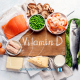 Mesa com vários alimentos que são ricos e m vitamina D. Há peixe, ervilha, queijo, leite, ovos e camarão.