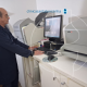 Técnico de rai0 X opera equipamento durante realização de exame.